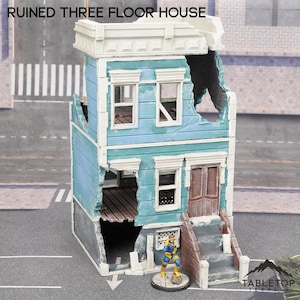 Puede incluir: Un modelo de casa de tres pisos en ruinas con un exterior azul y blanco. La casa tiene un gran agujero en el lateral y un conjunto de escaleras que conducen a la puerta principal. El modelo está hecho de plástico y está pintado en un estilo realista. El modelo está sentado sobre una superficie gris.  "RUINED THREE FLOOR HOUSE" está escrito en letras blancas sobre un fondo negro en la parte superior de la imagen.