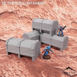 Könnte beinhalten: Ein Set grauer Lagerbehälter im Industriestil mit der Aufschrift 11E TERTIUS CONTAINERS, die ein verstärktes Kreuzstreben-Design und vertikal gerippte Enden aufweisen. Zwei kleine, blau gepanzerte Miniaturfiguren stehen zwischen den Behältern.
