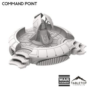 May include: A light gray Command Point terrain piece for tabletop games. The piece has a circular design with a central structure and detailed architectural elements. The text "COMMAND POINT" is at the top. The base has the text "WAR SCENERY" and "TABLETOP TERRAIN".
