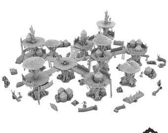 Op de afbeelding: Een gedetailleerd model van een bosmaan-dorp, met meerdere boomhutten die met elkaar verbonden zijn door loopbruggen. Het model is gemaakt van grijs plastic en bevat verschillende details zoals hutten, hekken en figuren. Het model is gelabeld met "FOREST MOON VILLAGE" en "TABLETOP TERRAIN".