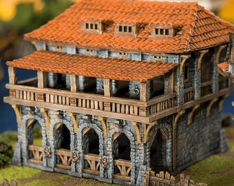 May include: A detailed miniature building with a red tile roof, stone walls, and wooden accents. The two-story structure features a balcony, arched openings, and a small fence. The image includes the text "PRINTABLE SCENERY".