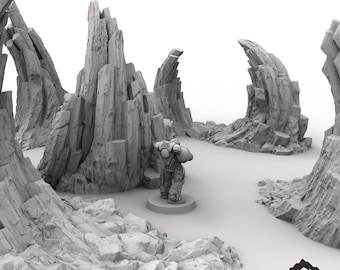 May include: A gray, rocky terrain with a miniature figure standing in the center. The terrain is made of jagged, angular rocks and is designed for tabletop gaming.