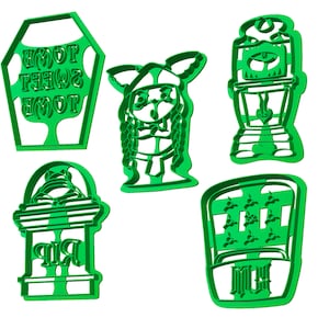 May include: A collection of five green plastic cookie cutters in various Halloween-themed shapes. The shapes include a tombstone with "RIP" text, a witch, a haunted house, a coffin with "Home Sweet Home" text, and a tombstone with "Me" text.