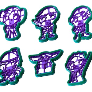May include: Six purple and green plastic cookie cutters featuring characters from a popular science fiction franchise. The cutters depict various characters in a cartoon style, with detailed outlines and shapes. The cutters are designed for baking and crafting.