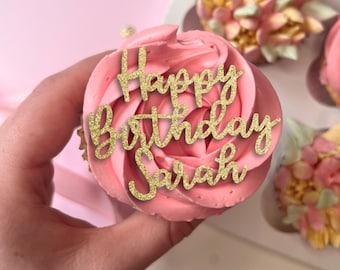 May include: Pink cupcake with a gold glitter Happy Birthday Sarah topper.