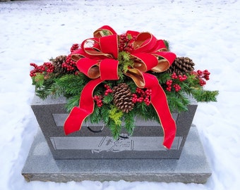 This Red Velvet, Gold backed Ribbon with Winter Greens, berries, and pine cones cemetery saddle is perfect for decorating the cemetery.