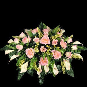 This Headstone Saddle has silk grave flowers including Cream Pink Calla Lilies and Roses. It is a perfect funeral or cemetery decoration.