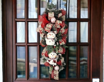 Christmas Front Door Wreath Swag with 2 snowmen, pine, berries, and 2 types of ribbon. Festive Holiday Porch Decoration.