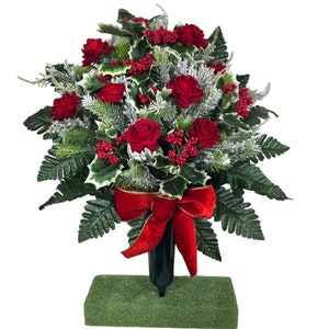 This Plentiful Christmas memorial cone has red roses, berries, holly, and snowy pine. This is a funeral or cemetery decoration.