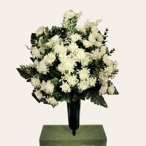 This cemetery cone has grave flowers including cream mini mums. It is perfect for a funeral or cemetery decoration.