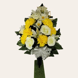 This cemetery cone has grave flowers including yellow roses, mums, and lilies. It is a perfect white & yellow summer memorial decoration.