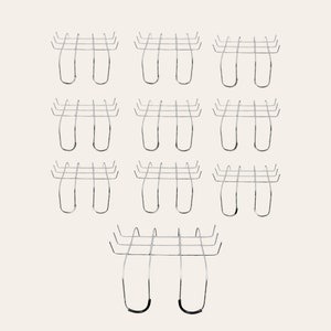 May include: A set of twelve silver metal hooks with a black rubber base. The hooks are designed to hang items on a wall or other surface.