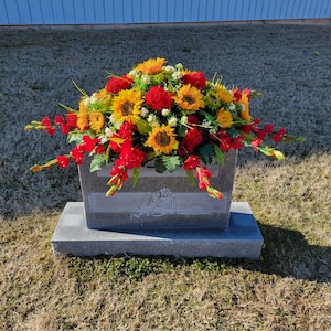 Sunflower Headstone Saddle with geranium grave flowers for cemetery memorial decoration.