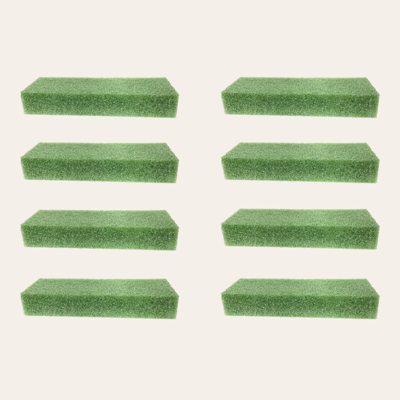 May include: Eight green rectangular floral foam bricks. The foam is designed for arranging flowers and greenery.