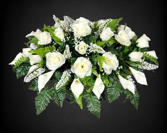 This Headstone Saddle has silk grave flowers including Cream Calla Lilies and Roses. It is a perfect funeral or cemetery decoration.