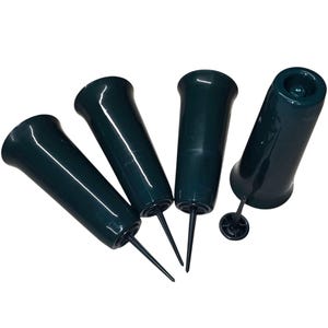 May include: Four dark green plastic flower frog vases with pointed spikes. The vases are designed to be inserted into floral arrangements.