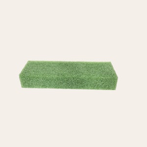 May include: A green rectangular block of floral foam, used for arranging flowers.