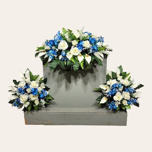 This headstone saddle and cemetery cone set has silk grave flowers including Cream Calla Lilies and Roses and Blue Tweedia.