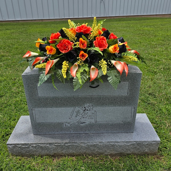 This headstone saddle is made of orange & black rose grave flowers. It's a memorial decoration for a motorcycle biker, Halloween, and fall.