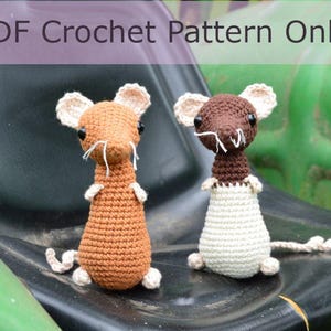 May include: Two handmade crochet mice, one orange and one brown, with white ears, whiskers, and feet, sit on a black surface. The image includes the text "PDF Crochet Pattern Only" in a purple banner at the top.