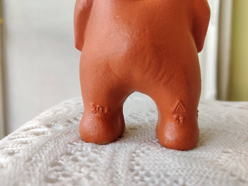 May include: A terracotta figurine of a bear with a triangular mark on the bottom of one foot and the number "30" on the other foot.