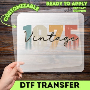 May include: A DTF transfer with the word "Vintage" in a script font, and the numbers "1975" in a retro color scheme. The transfer is labeled "Customizable" and "Ready to Apply".