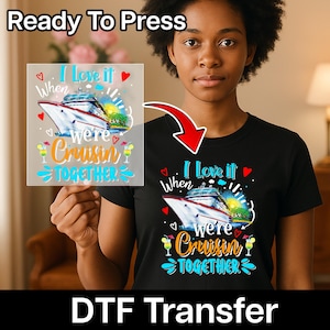 Op de afbeelding: Een zwart t-shirt met een kleurrijke afbeelding met de tekst "I Love it When We're Cruisin' Together", met een cruiseschip, harten en cocktails. De woorden "Ready To Press" en "DTF Transfer" zijn ook zichtbaar.