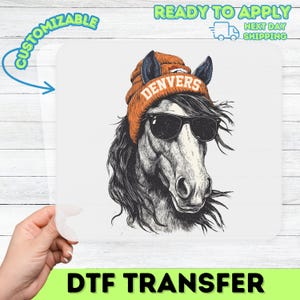 May include: A DTF transfer showing a horse wearing sunglasses and an orange Denver Broncos beanie. The horse is illustrated in black and white with long flowing hair. The transfer is on a white background with the words "Customizable" and "Ready to Apply" and "DTF TRANSFER".