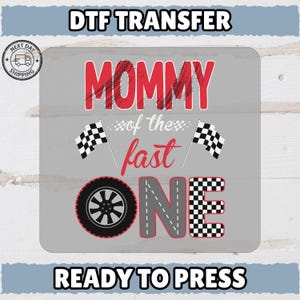 Op de afbeelding: Een grijze DTF-transfer met de tekst "MOMMY of the fast ONE" in rood en wit. Het ontwerp bevat een band, geblokte vlaggen en de woorden "READY TO PRESS".