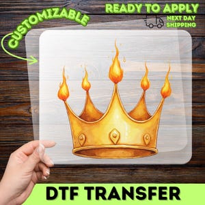 May include: A DTF transfer featuring a golden crown with orange flames atop each point. The image is on a clear background with the words "Customizable" and "Ready to Apply" and "Next Day Shipping".