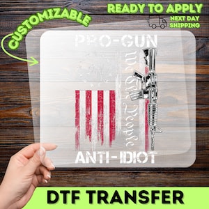 May include: A DTF transfer with an American flag design and a rifle graphic. Text includes "PRO-GUN", "We the People", and "ANTI-IDIOT". The transfer is labelled "CUSTOMIZABLE" and "READY TO APPLY".