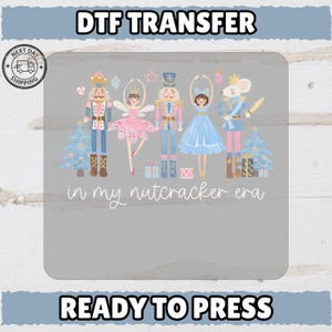 Puede incluir: Transferencia DTF con temática de Cascanueces. El diseño incluye ilustraciones de soldados Cascanueces, una bailarina y un rey ratón, con el texto "in my nutcracker era". Listo para planchar.
