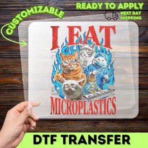 May include: A clear DTF transfer sheet featuring a graphic design with the red text I EAT MICROPLASTICS. The design includes four cats, one wearing glasses, one in a surgical gown with a mask, and blue flames in the background.