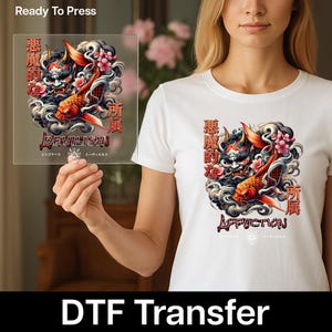 May include: White t-shirt and DTF transfer featuring a Japanese-inspired design with a red koi fish, a demon mask, and Japanese text. The transfer reads "DEVILISHN" and "Ready To Press".