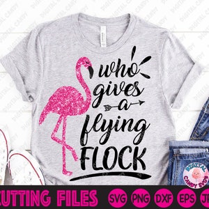 May include: A gray t-shirt with a pink glitter flamingo and the text "who gives a flying flock".