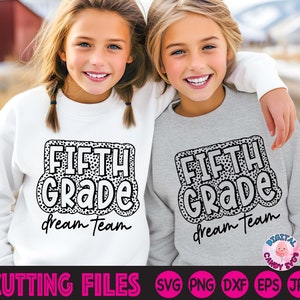 May include: Two children wearing white and grey sweatshirts with the text "FIFTH GRADE dream team" in black and white with a leopard print pattern. The text is in a bold, cartoon-like font.