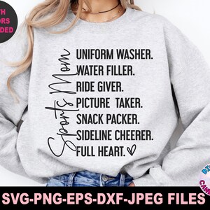 May include: A gray sweatshirt with the text "Sports Mom" and a list of duties: "Uniform Washer, Water Filler, Ride Giver, Picture Taker, Snack Packer, Sideline Cheerer, Full Heart."