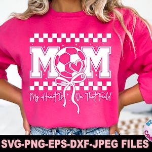 May include: Pink sweatshirt with a white graphic design of a soccer ball with a heart and the text "MOM My Heart Is On That Field".