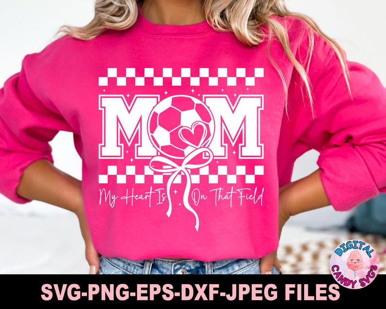 May include: Pink sweatshirt with a white graphic design of a soccer ball with a heart and the text "MOM My Heart Is On That Field".