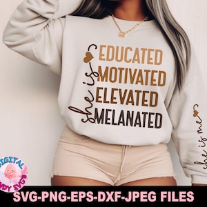 May include: A white sweatshirt with the text "She is educated, motivated, elevated, melanated" in brown lettering. The text is centred on the front of the sweatshirt. The sweatshirt is being worn by a person with brown hair and skin.