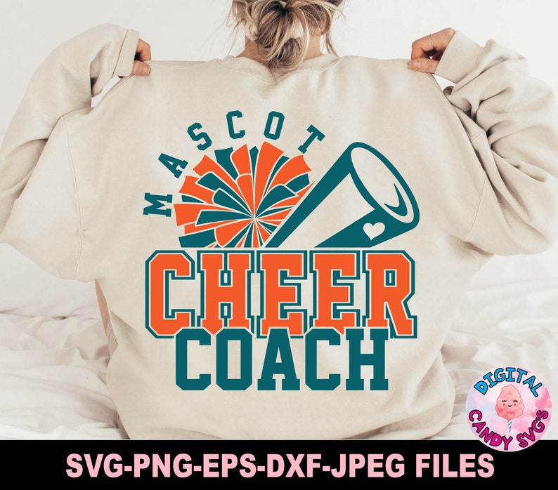 May include: A white sweatshirt with the text "MASCO7 CHEER COACH" in teal and orange. The design includes a teal and orange cheerleader pom-pom and a teal megaphone with a heart.