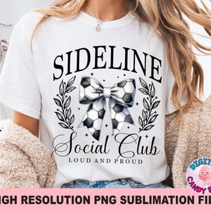 May include: White t-shirt with black text that reads "Sideline Social Club Loud and Proud". A black and white football bow is centered on the shirt.