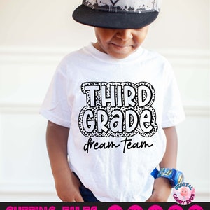 May include: A white t-shirt with black text that says "Third Grade Dream Team" in a bubble-like font with black polka dots.