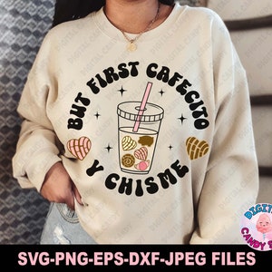 May include: A beige sweatshirt with the text "But first cafecito y chisme" in black. The text is in a circle with a pink and brown illustration of a coffee drink and pastries.