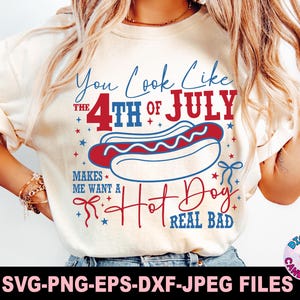 May include: Cream-colored t-shirt with a Fourth of July hot dog graphic. The design includes the text "You Look Like The 4th of July Makes Me Want A Hot Dog Real Bad" in red and blue. The image also includes the text "SVG-PNG-EPS-DXF-JPEG FILES".