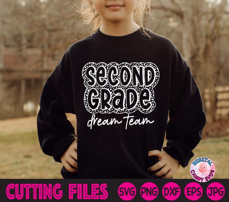 May include: A black sweatshirt with white text that says "Second Grade Dream Team" in a fun, playful font. The text is surrounded by a white polka dot pattern.