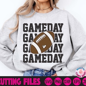 May include: A grey sweatshirt with the text "GAMEDAY" repeated four times, with a brown and white football graphic in the centre. The football has a small heart on it.