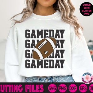 May include: White sweatshirt with the text "GAMEDAY" repeated four times in black. A brown and white football graphic is centred between the second and third lines of text.