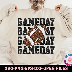 May include: A beige sweatshirt with the text "GAMEDAY" repeated four times in black glitter. A brown and white glitter football is centred on the sweatshirt.