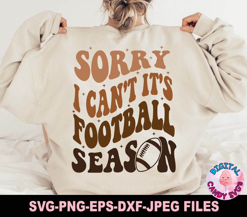 May include: A white sweatshirt with the text "SORRY I CAN'T IT'S FOOTBALL SEASON" in brown and orange letters. A brown football is in the middle of the text.